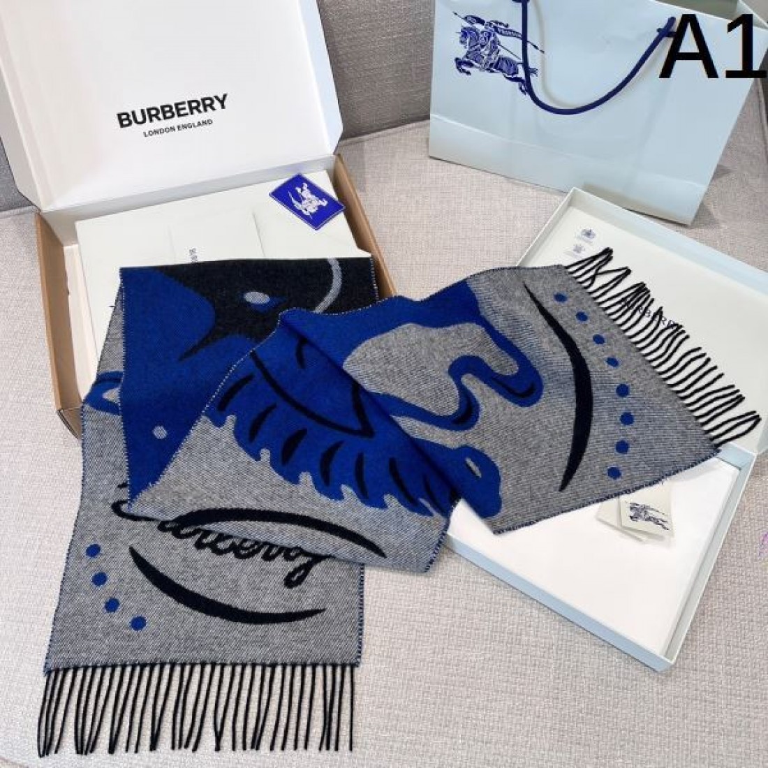 アート 個性 BURBERRY バーバリー コピー マフラー ブルー×グレー配色 グラフィック柄デザイン ロゴ入り フリンジ仕上げ 柔らかウール素材 存在感抜群