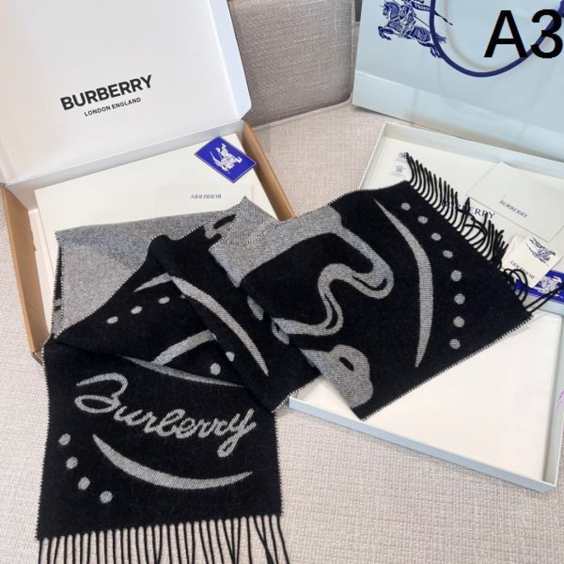 アート 個性 BURBERRY バーバリー コピー マフラー ブルー×グレー配色 グラフィック柄デザイン ロゴ入り フリンジ仕上げ 柔らかウール素材 存在感抜群