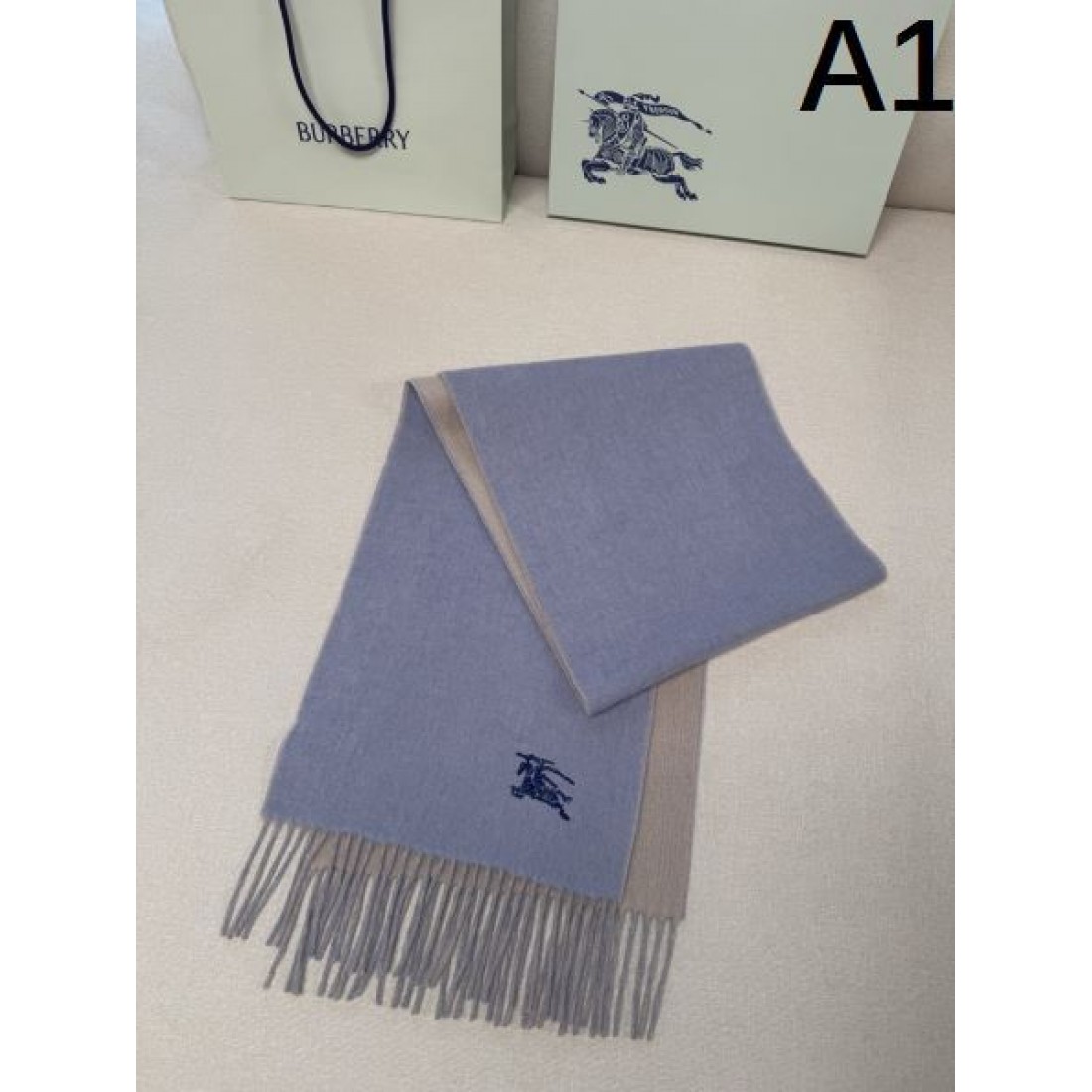 BURBERRY バーバリー コピー マフラー ライトブルー×グレー配色 ワンポイント騎士刺繍 フリンジ仕上げ 柔らかウール素材 上品な印象