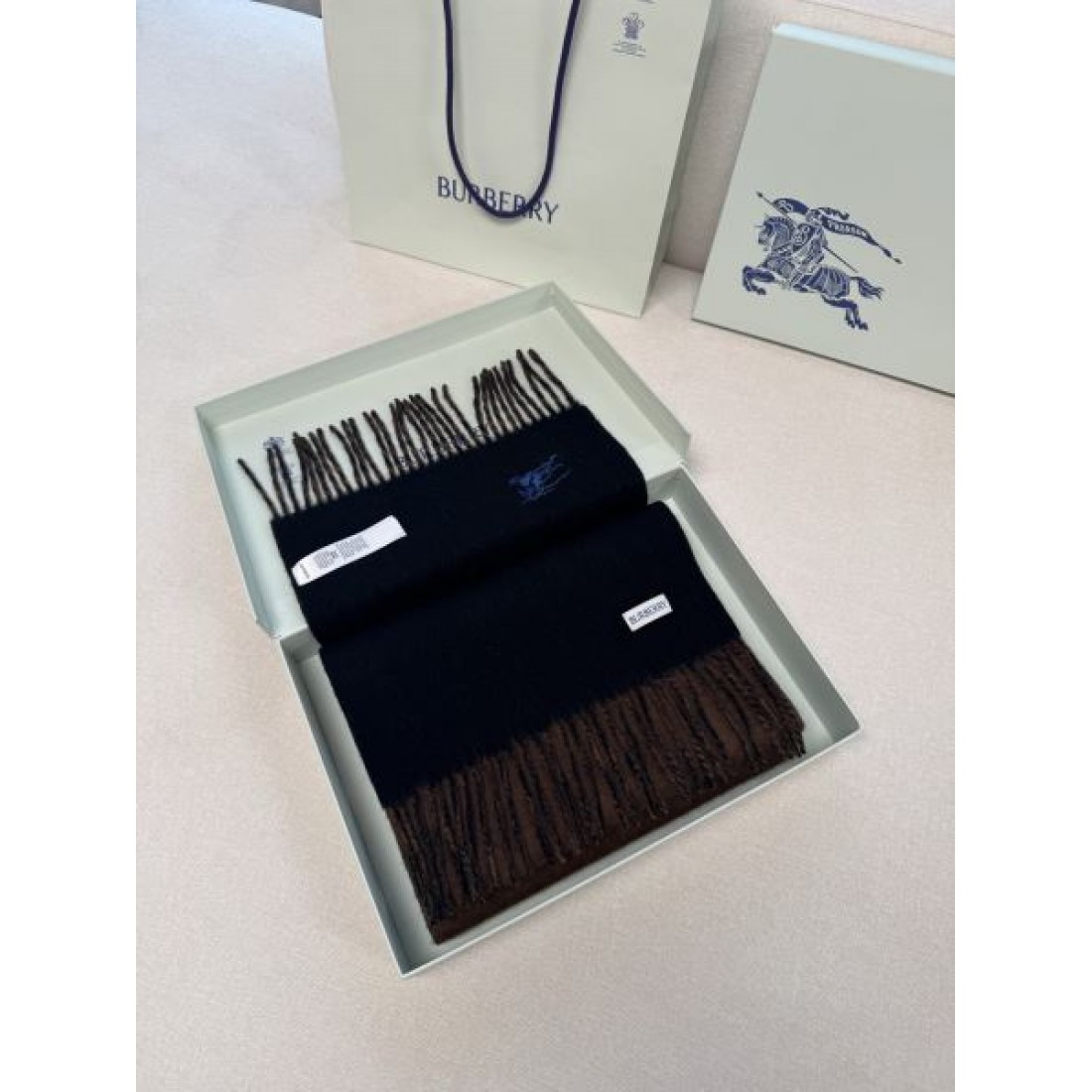 BURBERRY バーバリー コピー マフラー ライトブルー×グレー配色 ワンポイント騎士刺繍 フリンジ仕上げ 柔らかウール素材 上品な印象
