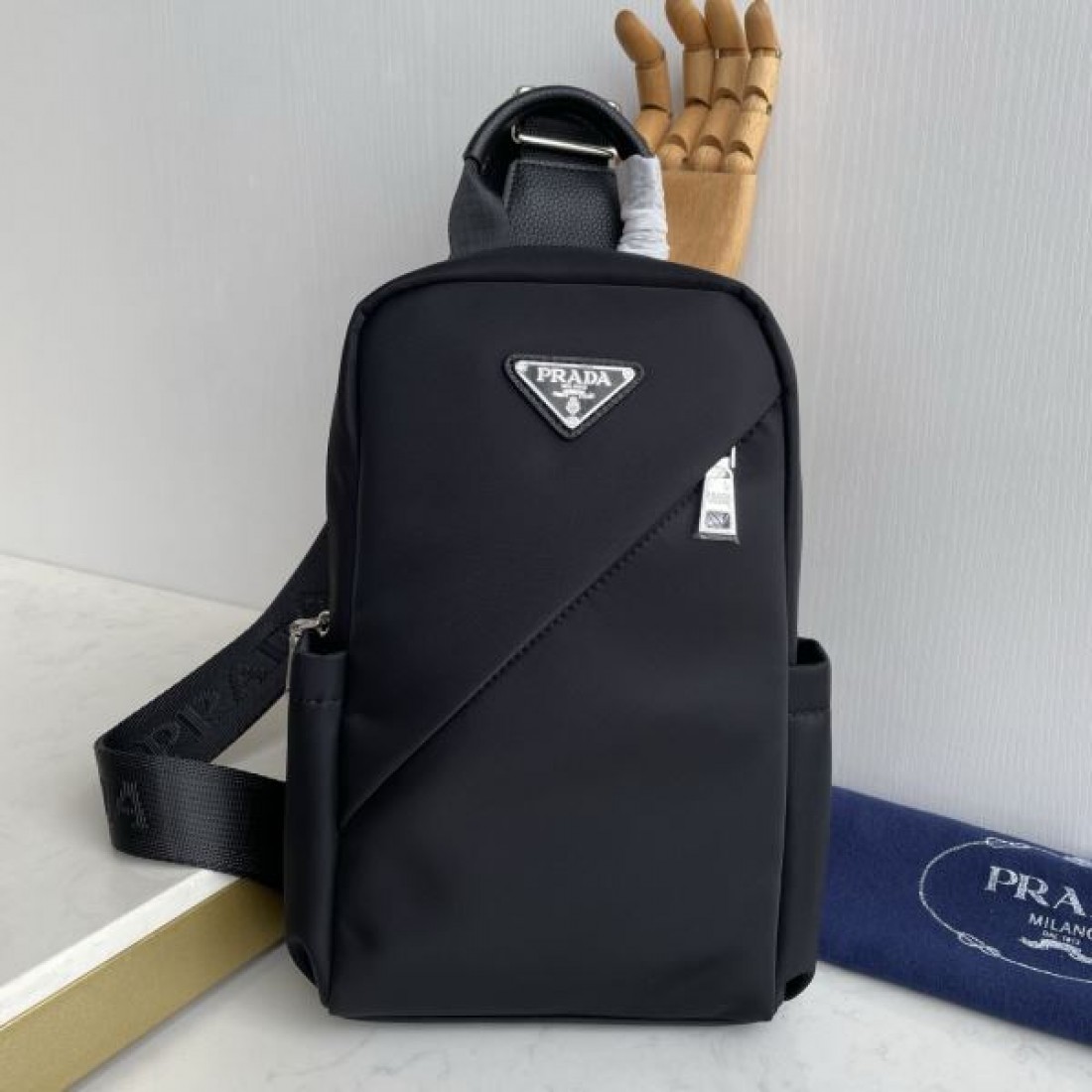 シンプル 高級感 PRADA プラダ コピー ボディバッグ ナイロン素材 縦型スリングバッグ ミニマルデザイン フロントロゴ 三角プレート 軽量設計 快適フィット