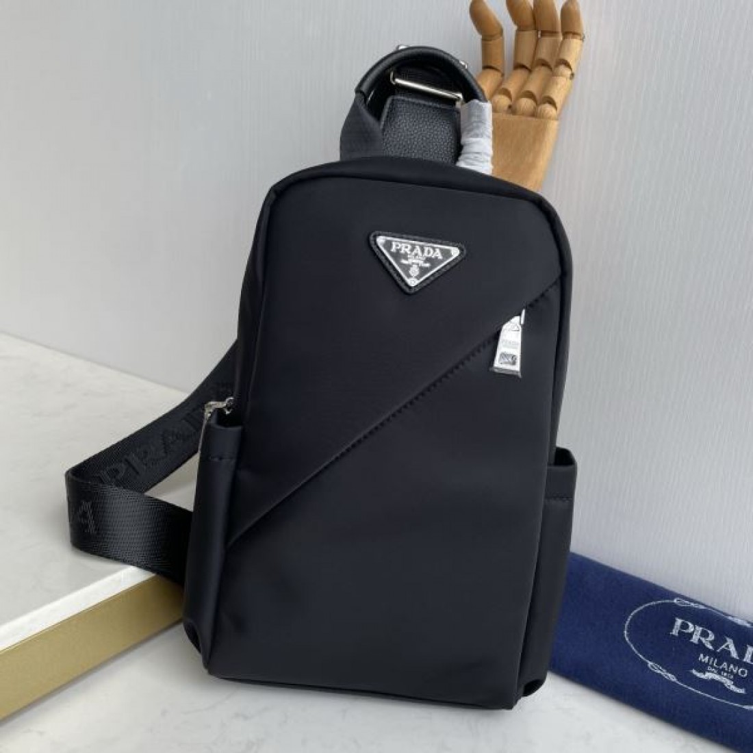 シンプル 高級感 PRADA プラダ コピー ボディバッグ ナイロン素材 縦型スリングバッグ ミニマルデザイン フロントロゴ 三角プレート 軽量設計 快適フィット