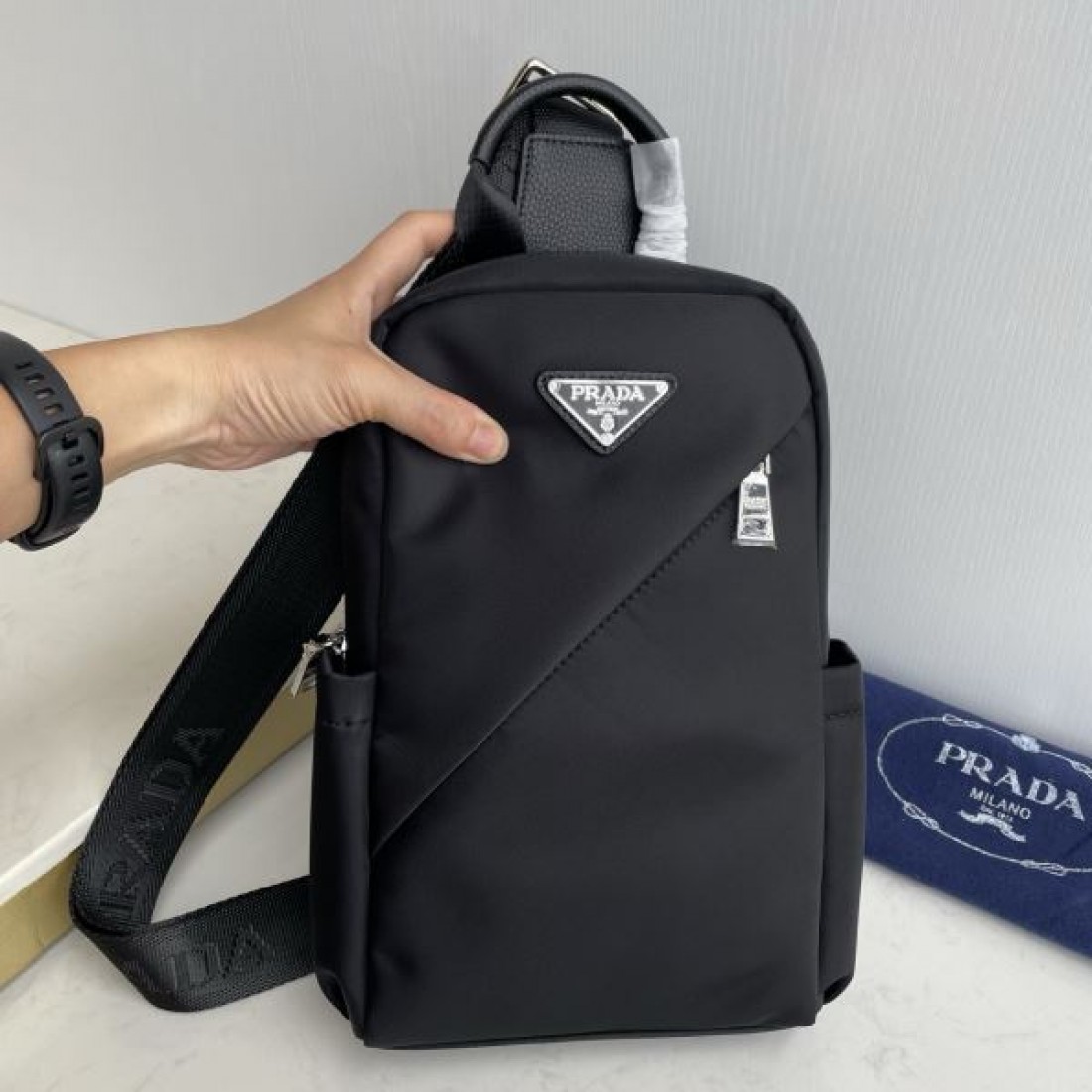 シンプル 高級感 PRADA プラダ コピー ボディバッグ ナイロン素材 縦型スリングバッグ ミニマルデザイン フロントロゴ 三角プレート 軽量設計 快適フィット