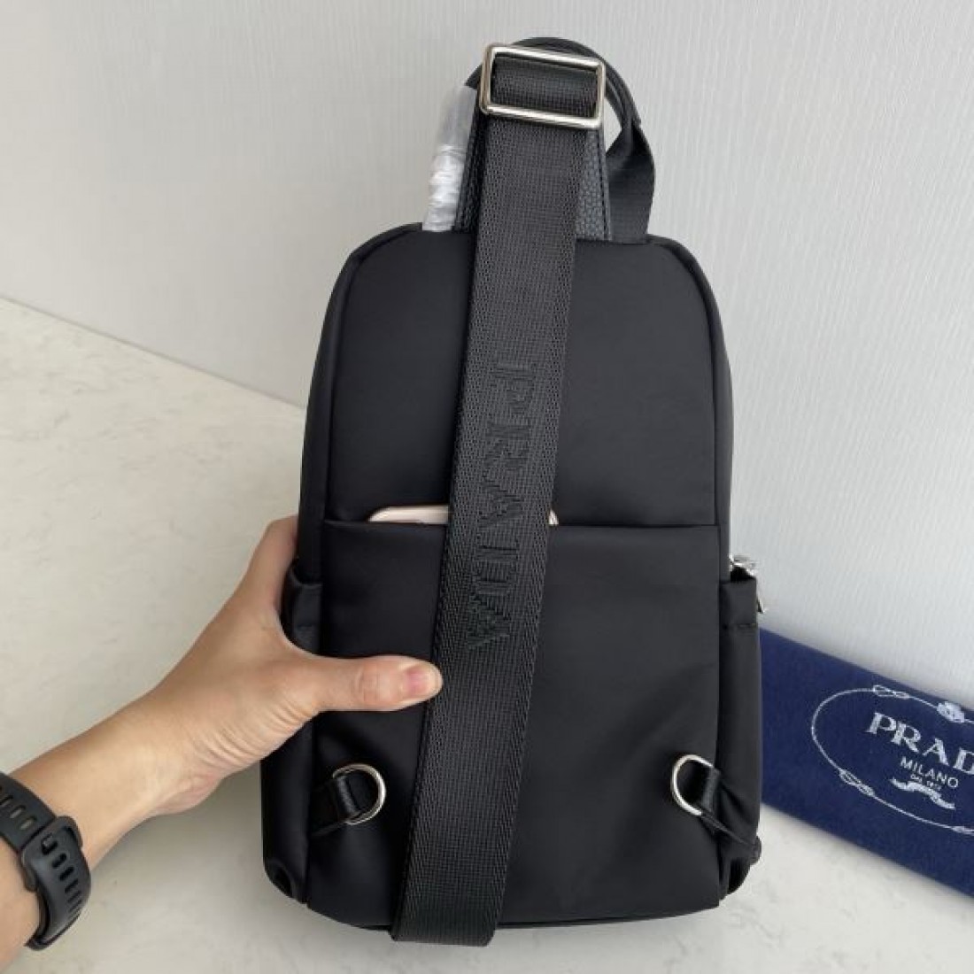 シンプル 高級感 PRADA プラダ コピー ボディバッグ ナイロン素材 縦型スリングバッグ ミニマルデザイン フロントロゴ 三角プレート 軽量設計 快適フィット