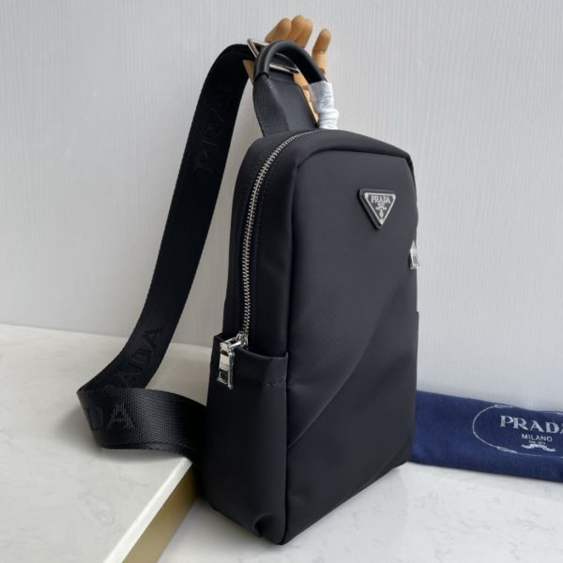 シンプル 高級感 PRADA プラダ コピー ボディバッグ ナイロン素材 縦型スリングバッグ ミニマルデザイン フロントロゴ 三角プレート 軽量設計 快適フィット