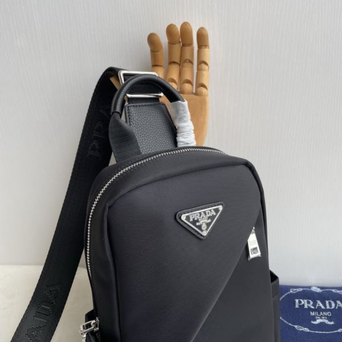 シンプル 高級感 PRADA プラダ コピー ボディバッグ ナイロン素材 縦型スリングバッグ ミニマルデザイン フロントロゴ 三角プレート 軽量設計 快適フィット