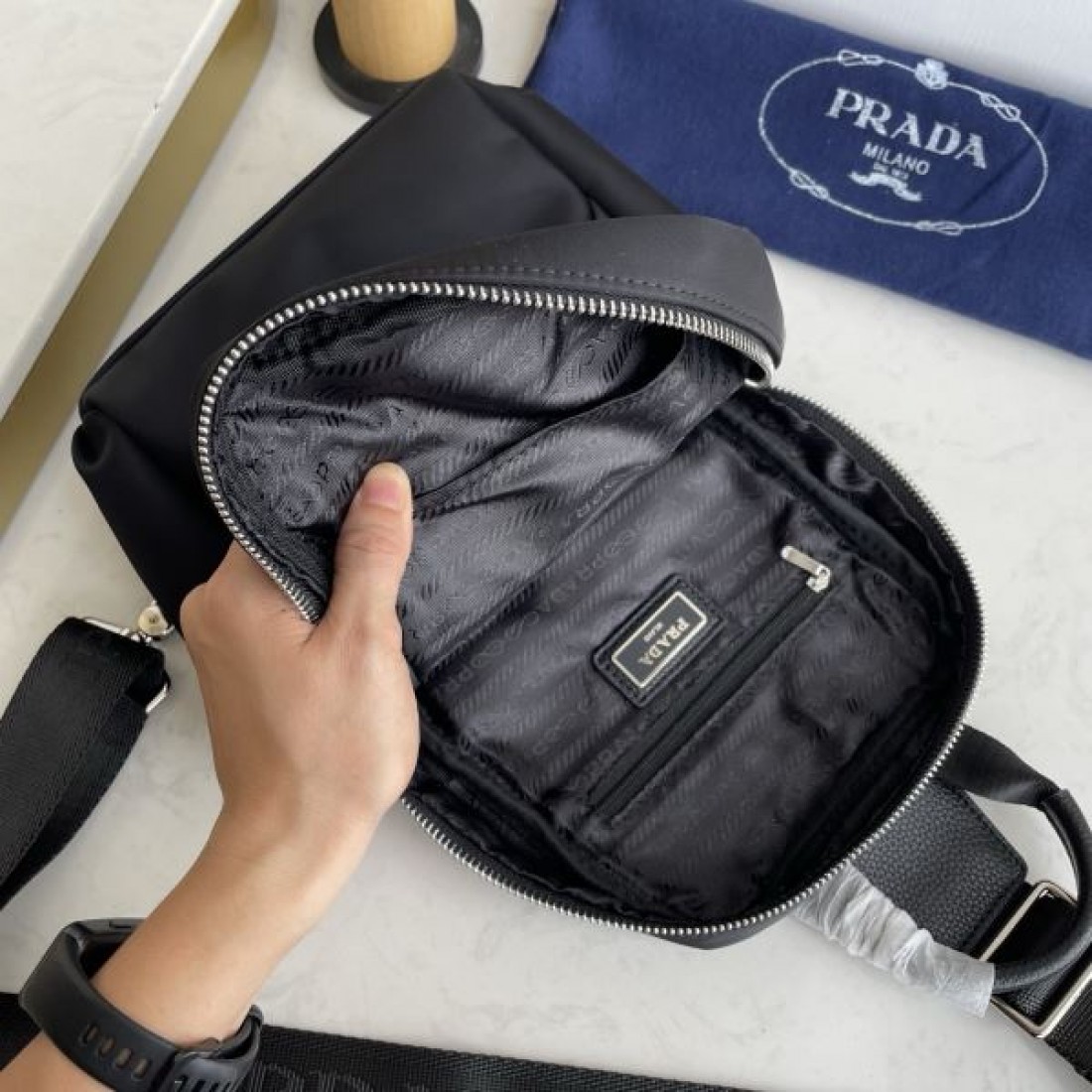 シンプル 高級感 PRADA プラダ コピー ボディバッグ ナイロン素材 縦型スリングバッグ ミニマルデザイン フロントロゴ 三角プレート 軽量設計 快適フィット