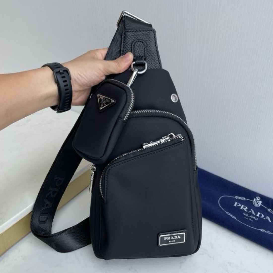スポーティ 洗練 PRADA プラダ コピー ボディバッグ ナイロン素材 スリングバッグ 縦型シルエット マルチポケット ロゴプレート 軽量設計 快適フィット