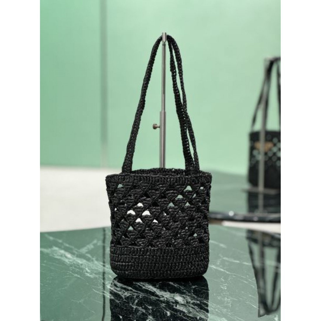 洗練 高級感 PRADA プラダ コピー バッグ ミニバケット 編み込みデザイン 軽量素材 ロゴ装飾 デイリー使い リゾートスタイル