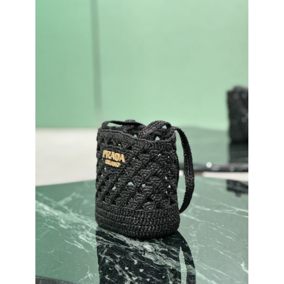 洗練 高級感 PRADA プラダ コピー バッグ ミニバケット 編み込みデザイン 軽量素材 ロゴ装飾 デイリー使い リゾートスタイル