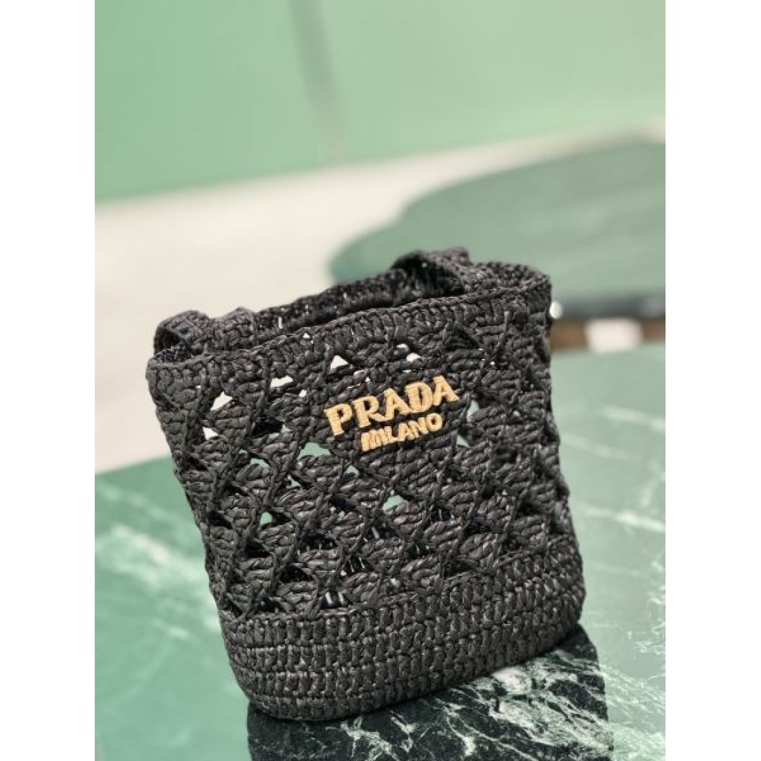 洗練 高級感 PRADA プラダ コピー バッグ ミニバケット 編み込みデザイン 軽量素材 ロゴ装飾 デイリー使い リゾートスタイル