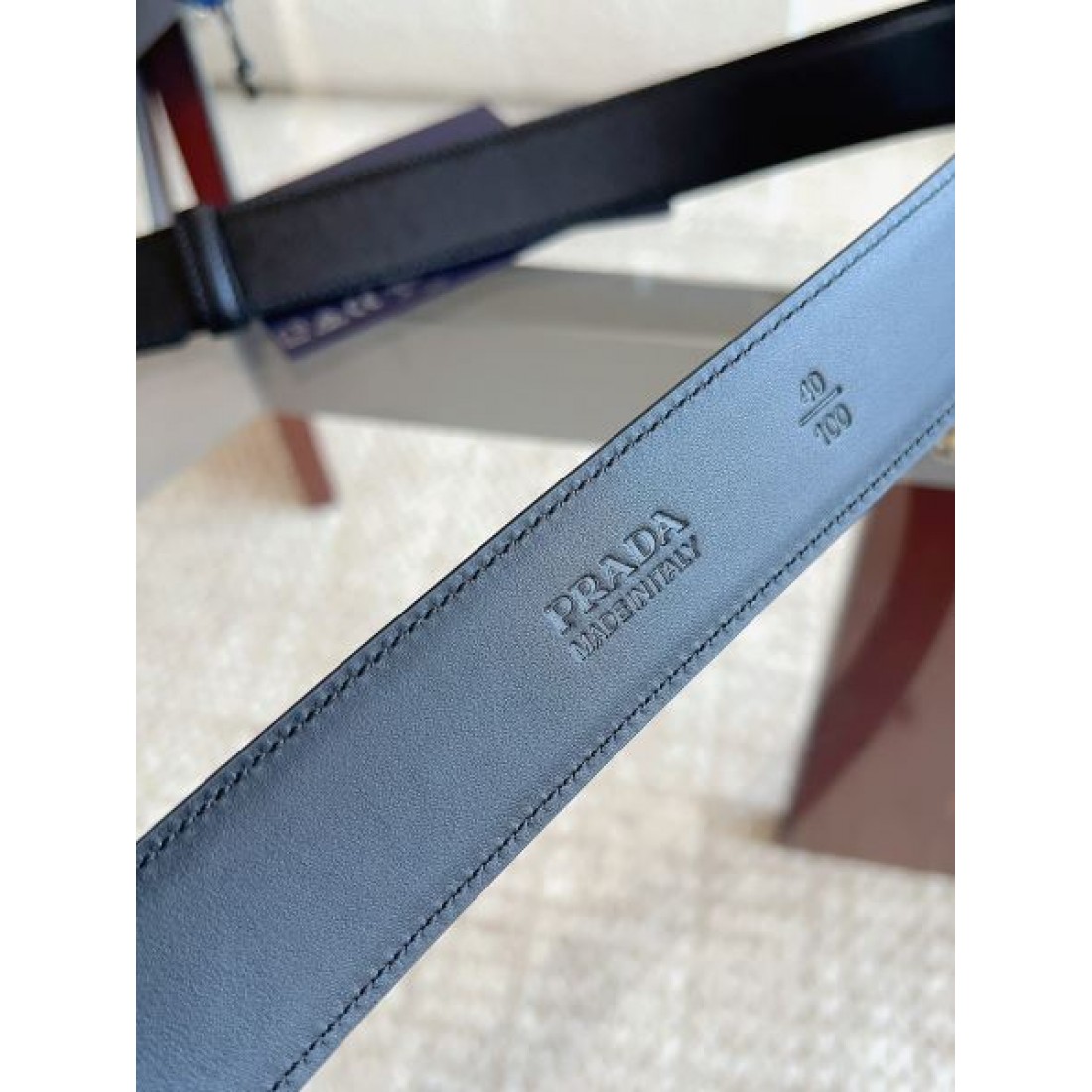 シャープ輪郭 Prada プラダ コピー ベルト ブラックレザー 細かなエンボス加工 サークルメタルバックル ロゴ刻印 都会的スタイル