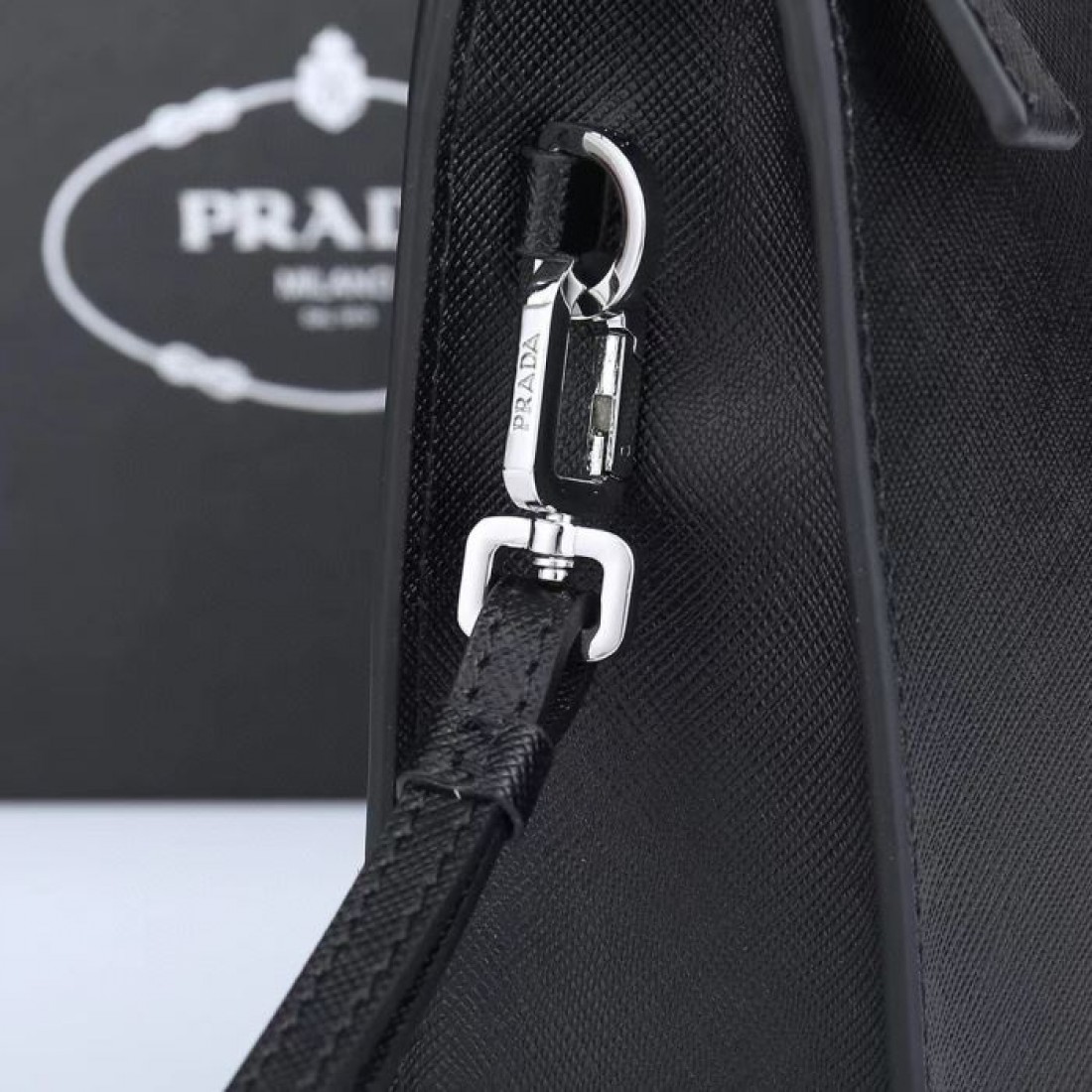 洗練されたブラックと上品な三角ロゴが印象的なPRADAプラダコピークラッチバッグ手首に掛けて持ち歩けるストラップ付きでビジネスから普段使いまで活躍