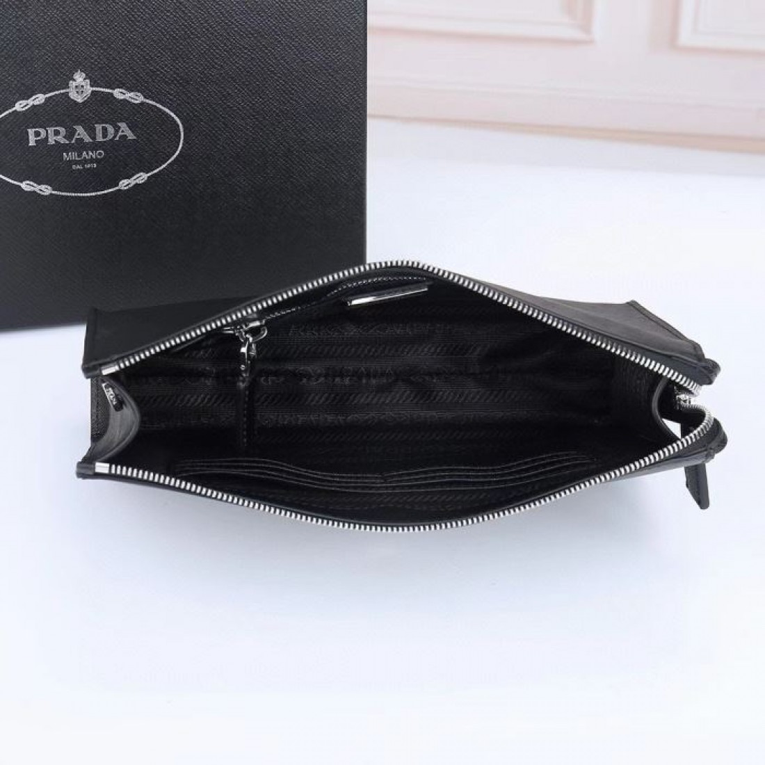 洗練されたブラックと上品な三角ロゴが印象的なPRADAプラダコピークラッチバッグ手首に掛けて持ち歩けるストラップ付きでビジネスから普段使いまで活躍