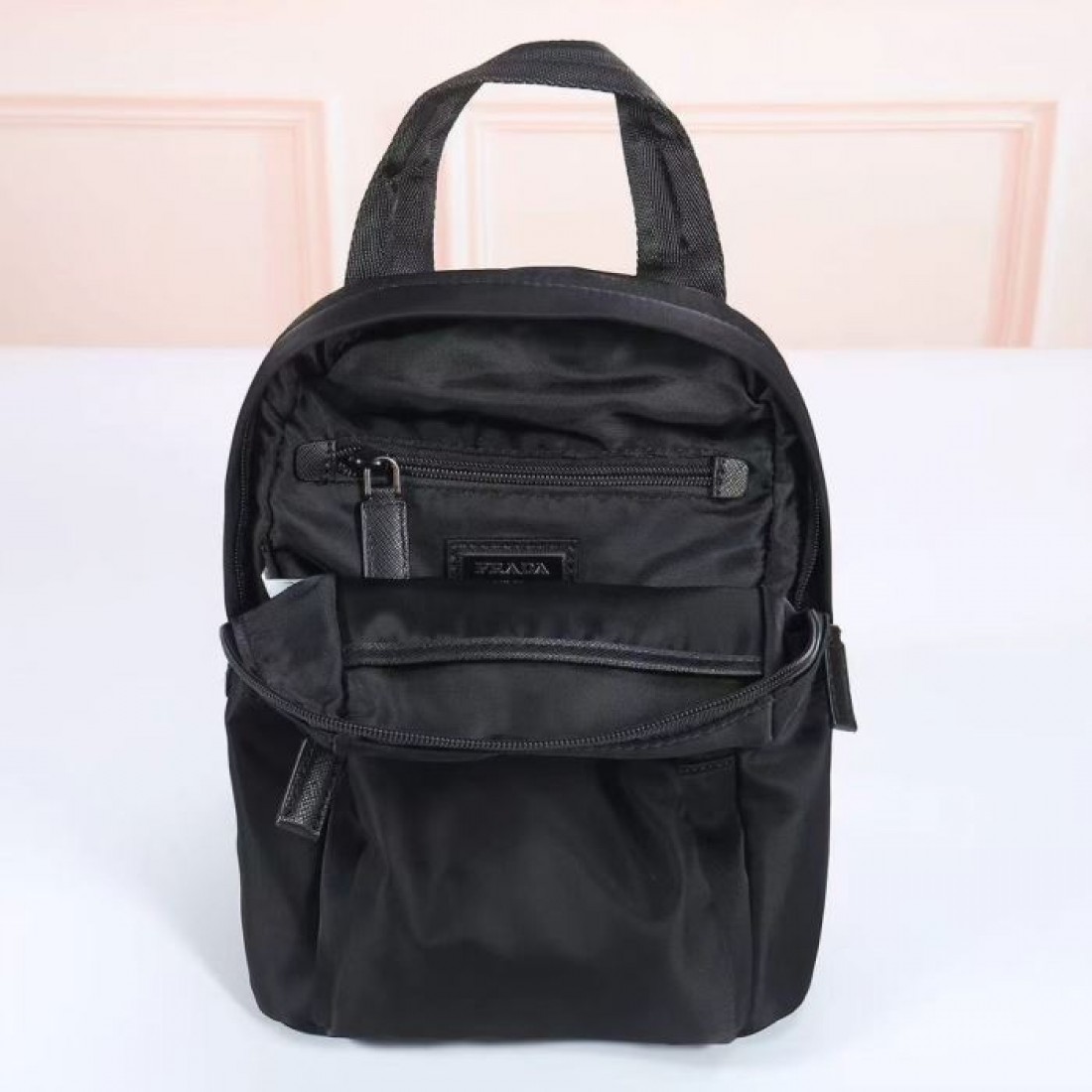 休日の街歩きにさりげない高級感を添えるPRADAプラダコピーバックパックブラックの落ち着いた佇まいと収納しやすいポケットが魅力