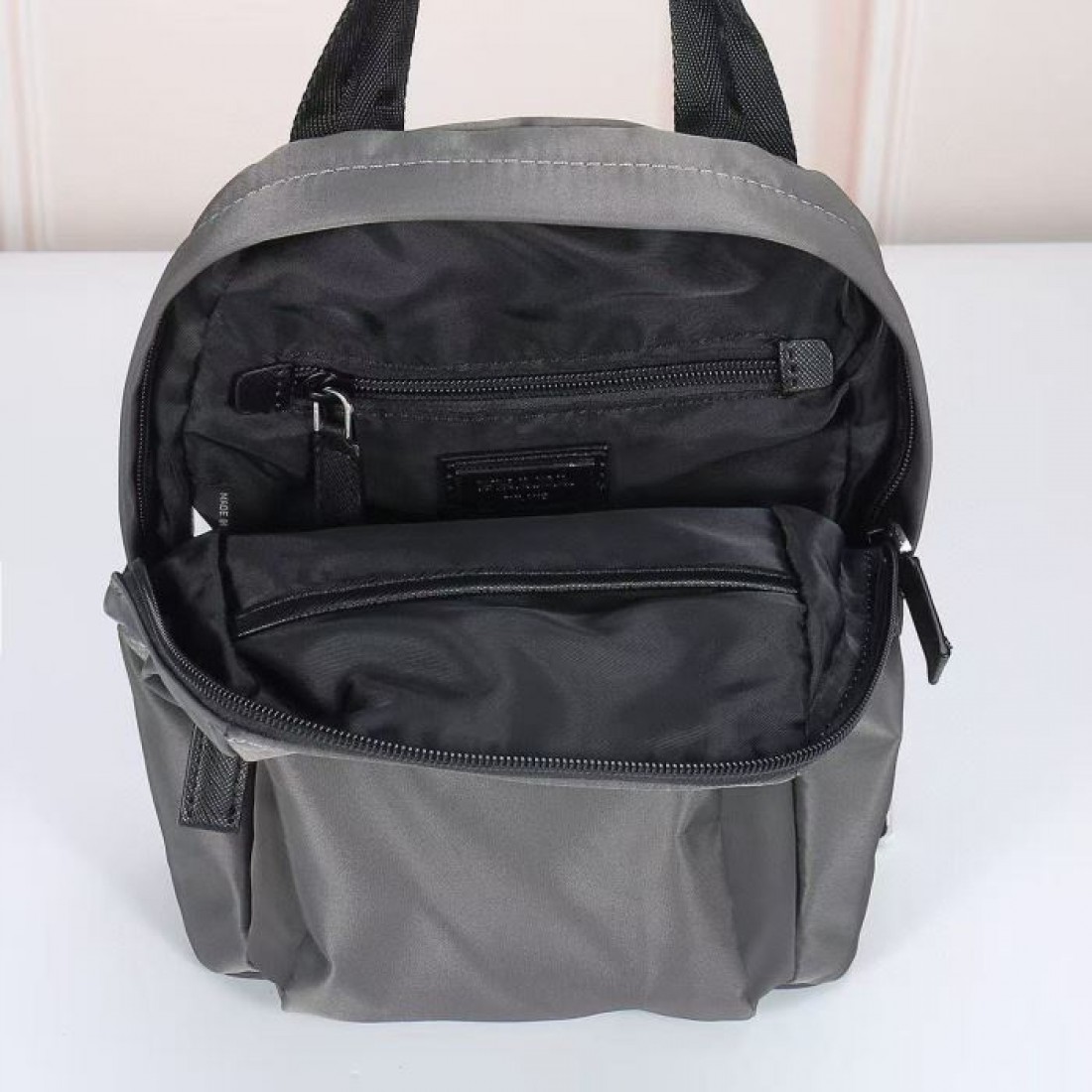 上品なチャコールグレーで季節を問わず使いやすいPRADAプラダコピーリュックコンパクトな見た目と実用的な収納を両立した街歩きや旅行のお供に